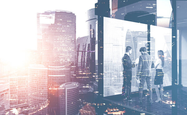 Two businessmen and businesswoman discussing documents in panoramic office. Double exposure of Moscow city and modern cityscape. Toned image