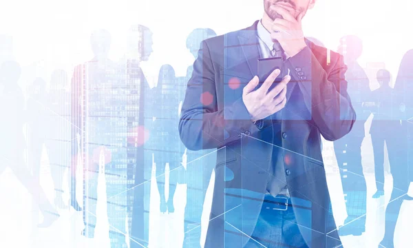 沉思的年轻商人穿着深色西装 拿着智能手机站在摩天大楼背景与他的商业团队 团队合作的概念 色调图像双重曝光模拟 — 图库照片