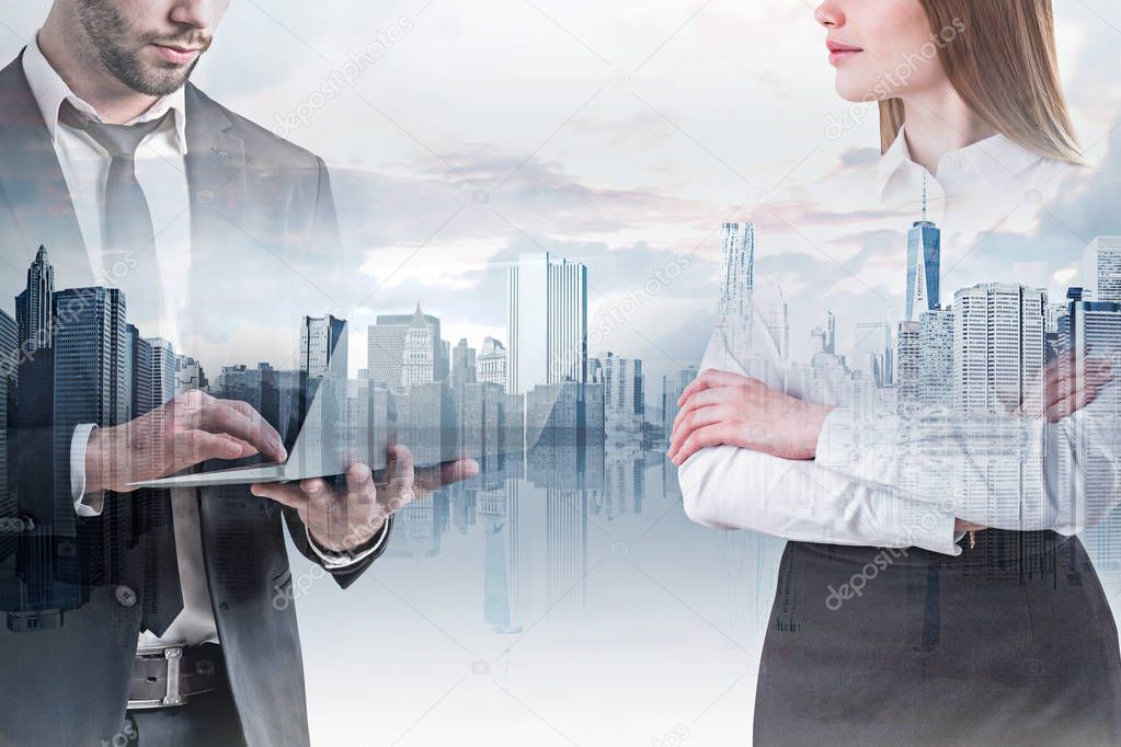 Unrecognizable businessman using laptop and confident businesswoman standing with crossed arms over modern cityscape background. Concept of management. Toned image double exposure