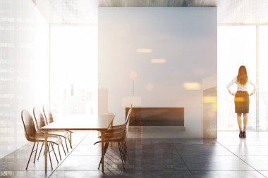Kadın iç beyaz duvarlar ile yemek odası minimalist gri döşeli kat, büyük pencereler, şömine ve sandalye ile gri tablosudur. Çift tonlu görüntü pozlaması