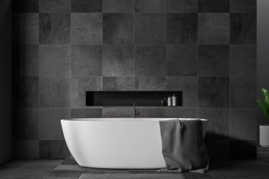 Şık banyo iç siyah taş duvarlar ve zemin ile gri havlu ve gri halı üzerinde asılı beyaz banyo küvetinde yakın çekim. 3D render