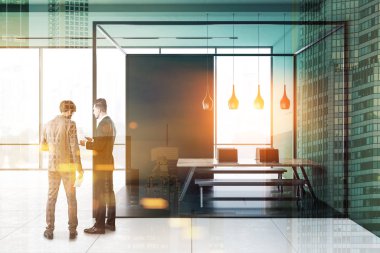 İki işadamları özgün panoramik ofiste siyah ve cam odada banklar ile yeşil duvarlar, kiremitli kat ve uzun ahşap masa ile iç konuşuyor. Çift tonlu görüntü pozlaması