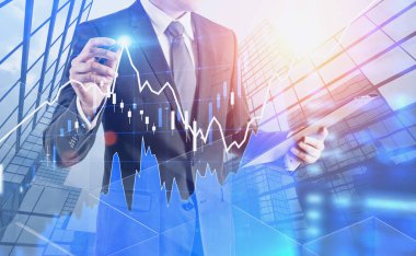 Tanınmayan işadamı ile forex grafik gökdelenler arka plan üzerinde parlayan kalemle çizim Pano. Borsa kavramı. Çift tonlu görüntü pozlaması