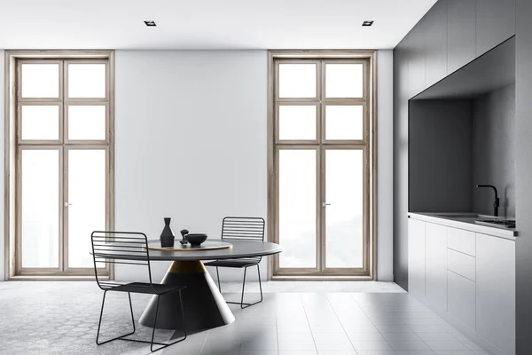 现代厨房的侧视图 白色的墙壁 蜂窝图案的地板 灰色的台面和黑色的圆桌与金属椅子 — 图库照片