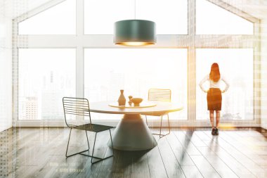 İç tavan yemek odası beyaz duvarlar ve tavan, koyu ahşap zemin, büyük pencere ve metal sandalyeler ile yuvarlak masa ile kadın. Çift tonlu görüntü pozlaması