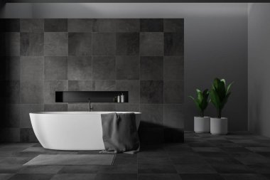 Gri ve siyah taş duvarlar, beyaz küvet ve gri halı üzerinde asılı gri havlu ile ile şık banyo iç. 3D render