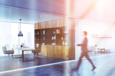 Ahşap kitaplık Yöneticisi Oda ve tablo ve salon odası Beyaz kanepe ve koltuklar ile office koridorda yürürken iş adamı. Görüntü bulanık tonda