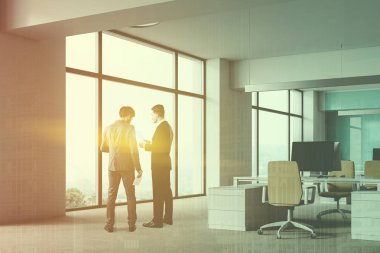 Businesmen açık alan office beyaz duvarlar ve zemin, geniş pencereler ve bej sandalye ile beyaz bilgisayar masaları ile köşesinde. Çift tonlu görüntü pozlaması