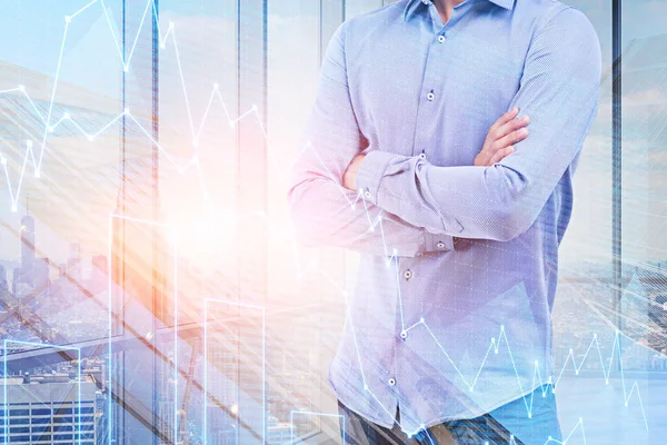 Unrecognizable businessman standing with crossed arms in panoramic office with cityscape and double exposure of graphs. Toned image