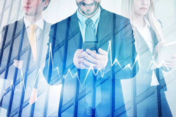 Smiling businessman with smartphone, blonde businesswoman with copybook and serious businessman with crossed arms standing over skyscraper background with double exposure of graph