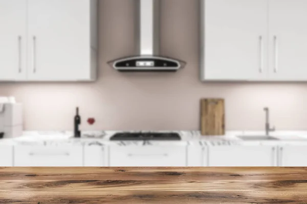 白色厨房台面内置炊具和水槽和白色柜子在他们的上方位于厨房与米色的墙壁 前景中的木桌 渲染模糊 — 图库照片
