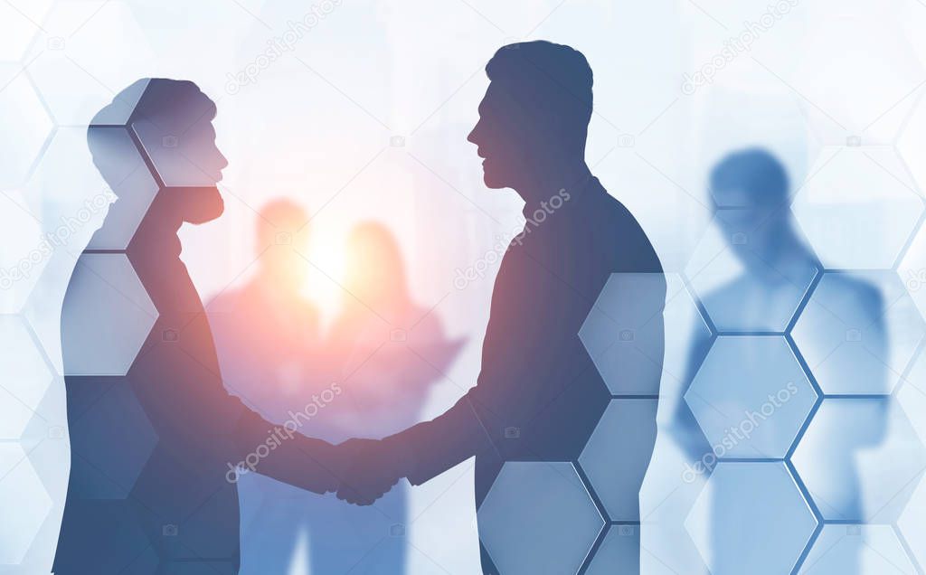 Silhouettes of business people shaking hands with their colleagues in background with double exposure of hexagonal pattern. Concept of partnership. Toned image