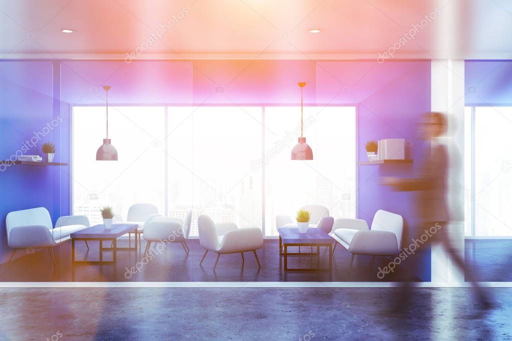 Businessman in interior of office waiting room with blue walls, panoramic window, white sofas and armchairs standing near blue coffee tables and bookshelves. Toned image blur
