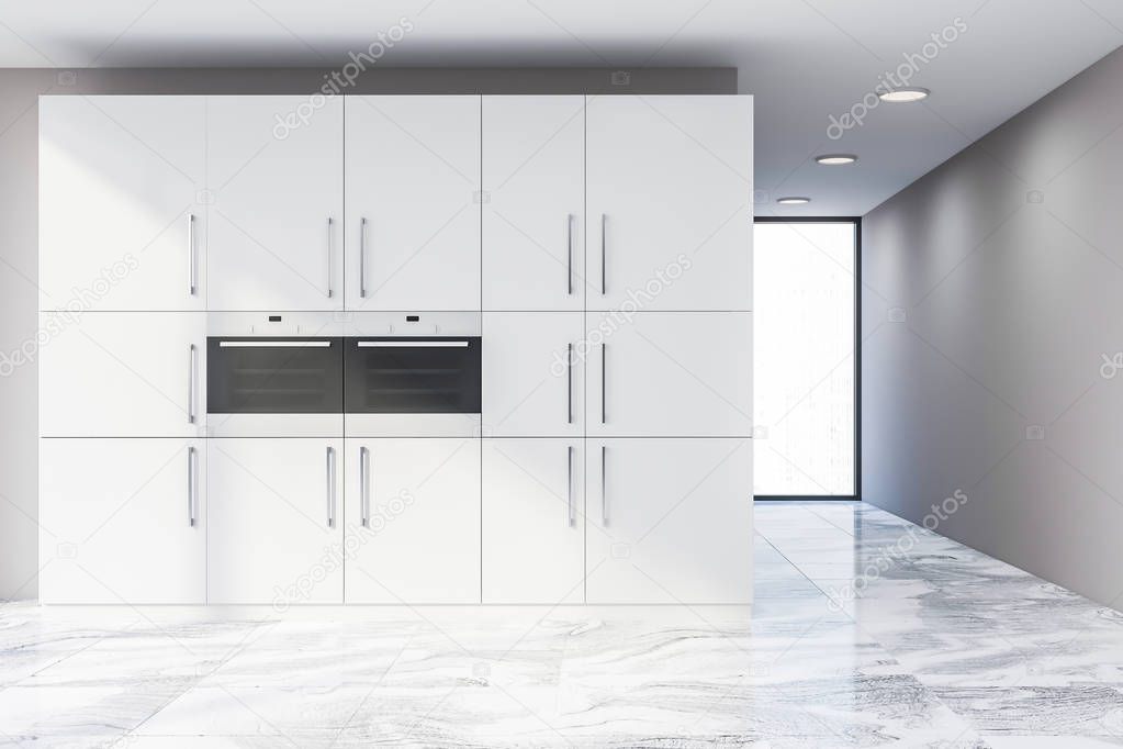 Interior of minimalistic kitchen with beige walls, marble floor, loft window and white cupboards with two built in ovens. 3d rendering