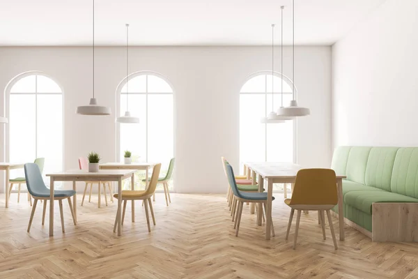 Interior of restaurant with white walls, wooden floor, arched windows, green sofa and pastel colored chairs standing near square wooden tables. 3d rendering