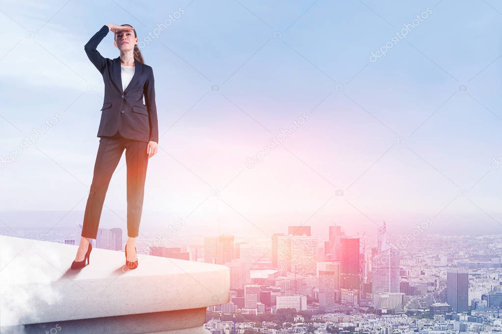 Young businesswoman in dark suit looking forward standing on rooftop over cityscape background. Concept of future of business. Toned image