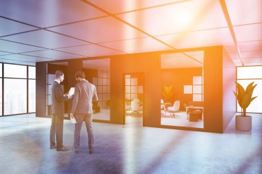 Siyah ve beyaz toplantı salonu beton zemin, beyaz sandalye ile uzun ahşap masa ve gri ve beyaz kanepeler ile modern ofis lobisinde iş adamları. Tonlu görüntü