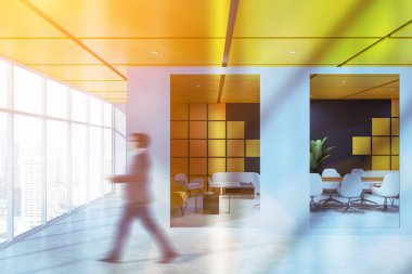 Ofis lobisinde panoramik pencere ve siyah ve sarı toplantı salonu beton zemin, beyaz sandalye ile uzun ahşap masa ve beyaz ve sarı kanepeler ile iş adamı. Görüntü bulanık tonda