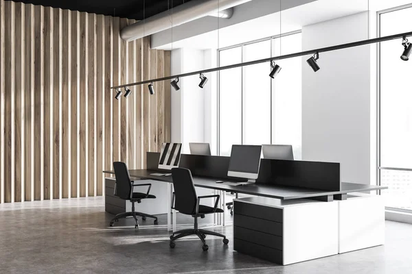 Corner of industrial style office with white and wooden walls, concrete floor, row of white computer desks near window and black computer tables. 3d rendering