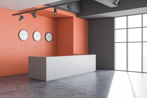 Corner of modern office with orange and gray walls, concrete floor, gray reception desk with clocks above it and large window. 3d rendering