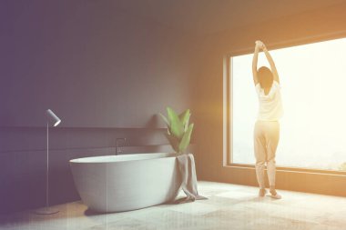 Kadın gri banyo köşede, beyaz küvet