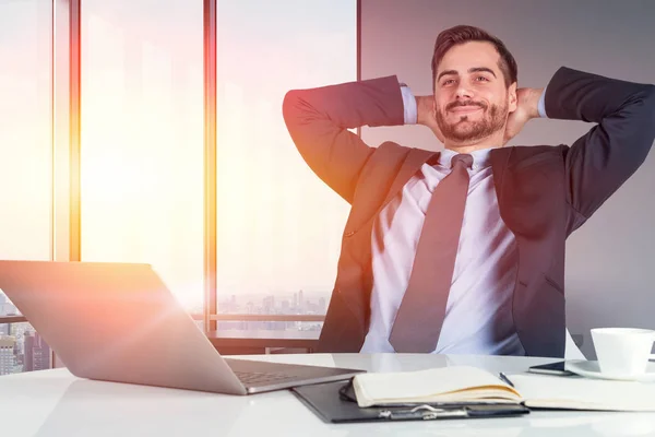 Avslappnad affärsman med laptop i office — Stockfoto