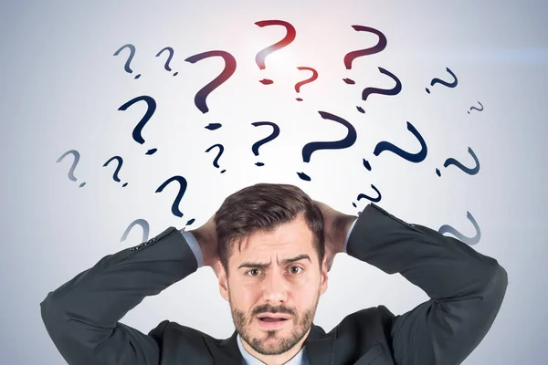 Empresário confuso, pontos de interrogação cinzentos — Fotografia de Stock