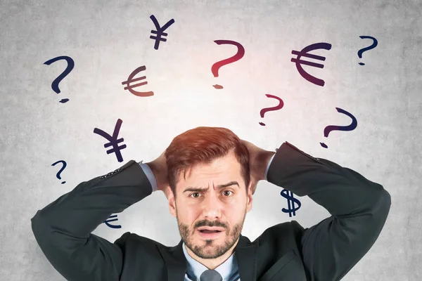 Confused businessman, currency signs — Stock Photo, Image