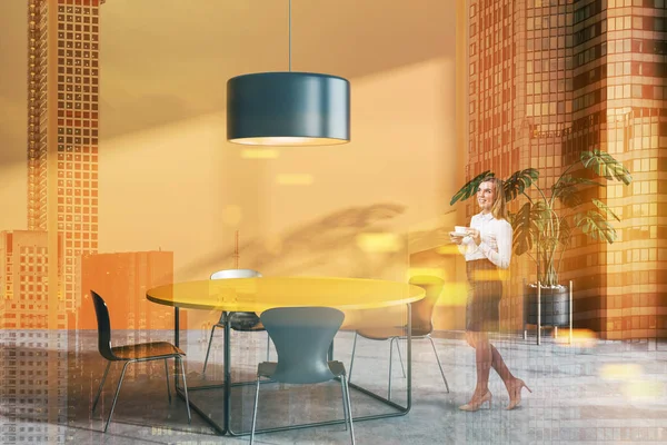 Kvinna i orange matsal med gul tabell — Stockfoto