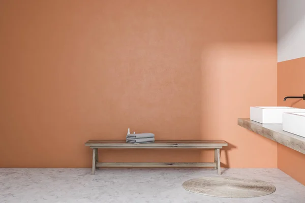 Orange bathroom with double sink and bench