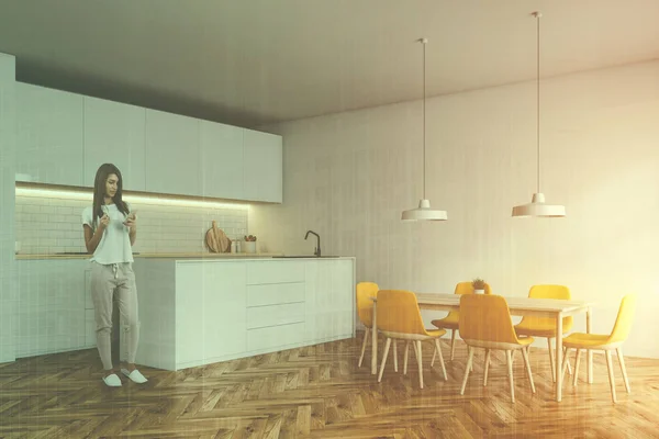 Mulher no canto da cozinha com cadeiras amarelas e bar — Fotografia de Stock