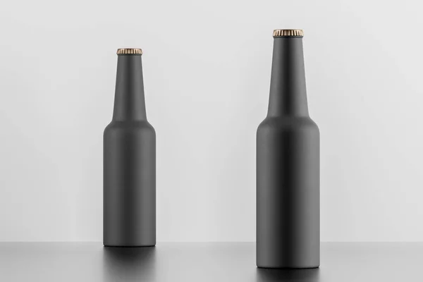 Beyaz arka plan üzerinde iki mat siyah şişe — Stok fotoğraf