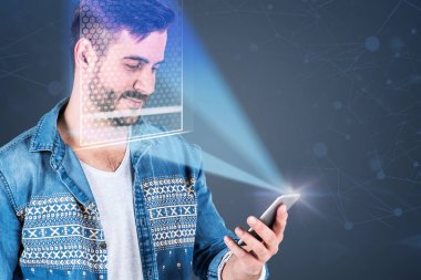 Genç adam akıllı telefon yüz tanıma ile gülümseyen