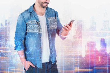 Gülümseyen adam telefon, şehir diyagramında bakarak