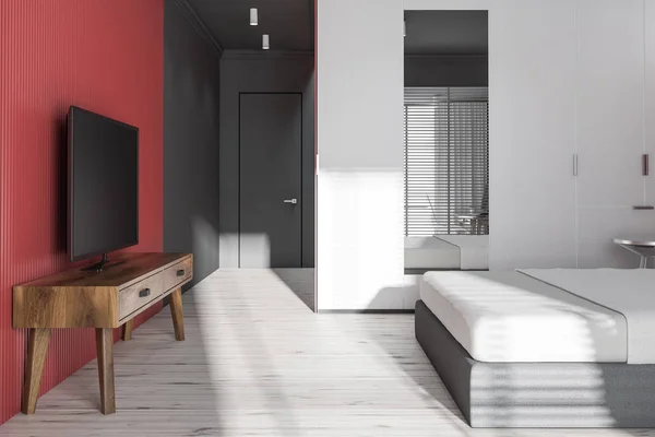 Side view of gray and red bedroom with tv set