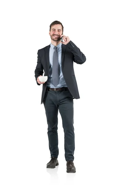 Glimlachend zakenman met koffie op telefoon, geïsoleerd — Stockfoto