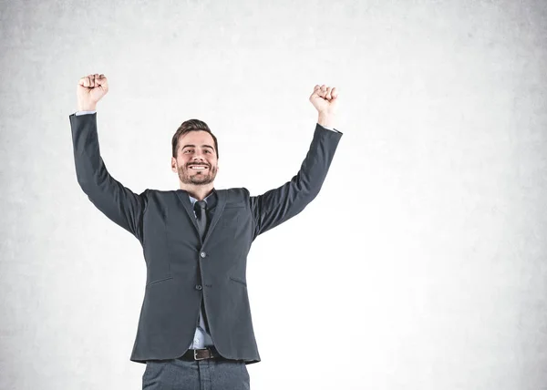 Businessman celebrating victory, concrete wall Royalty Free Stock Photos