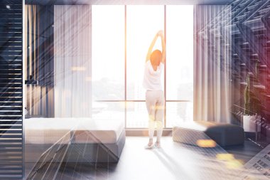 Kadın yatak odasında pencere bakıyor