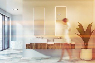 Beyaz banyoda kadın, lavabo ve küvet