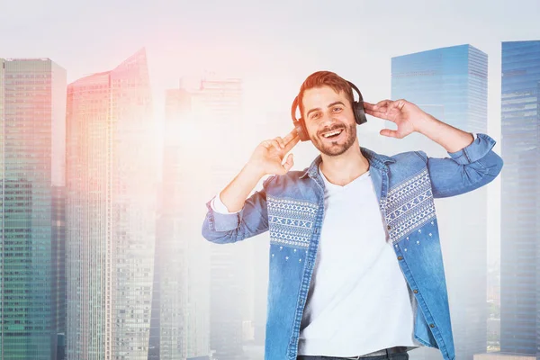 Щасливий чоловік в навушниках в сучасному місті — стокове фото