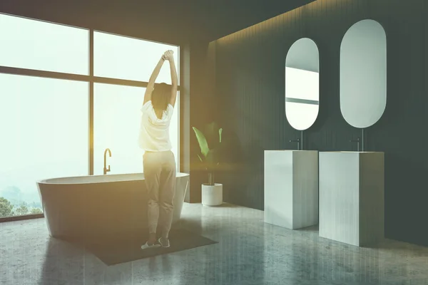 Žena v šedé koupelně se dřezem a vanou — Stock fotografie
