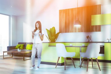 Kanepe ile parlak mutfakta kadın