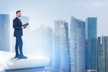 Gökdelenin çatısında kendine güvenen bir işadamı. Plan