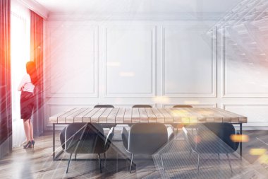 Ahşap masalı yemek odasında bir kadın var.