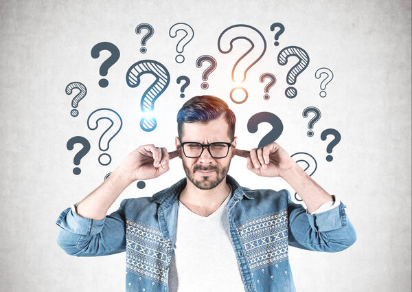 Man covering ears, question marks