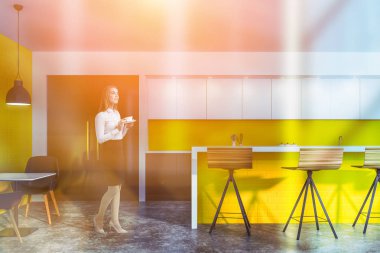 Parlak sarı kafede kahveli genç bir kadın.