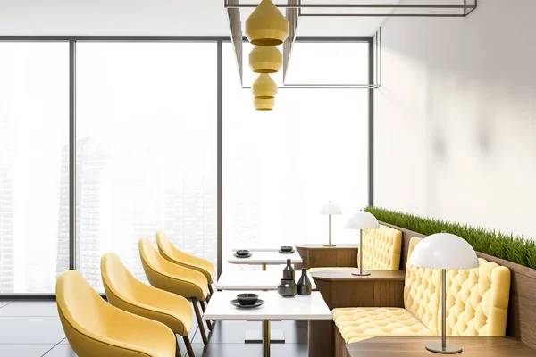 Panoramatická kavárna se žlutými pohovátky a židlemi — Stock fotografie