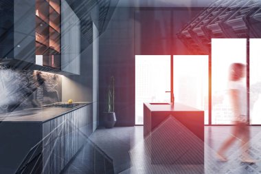 Gri mutfakta adayla yürüyen bir kadın