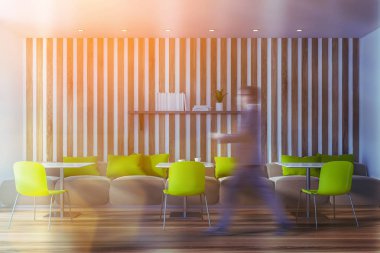 Parlak yeşil kafede yürüyen adam