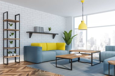 Beyaz ofis bekleme odası köşesi, mavi koltuklar.